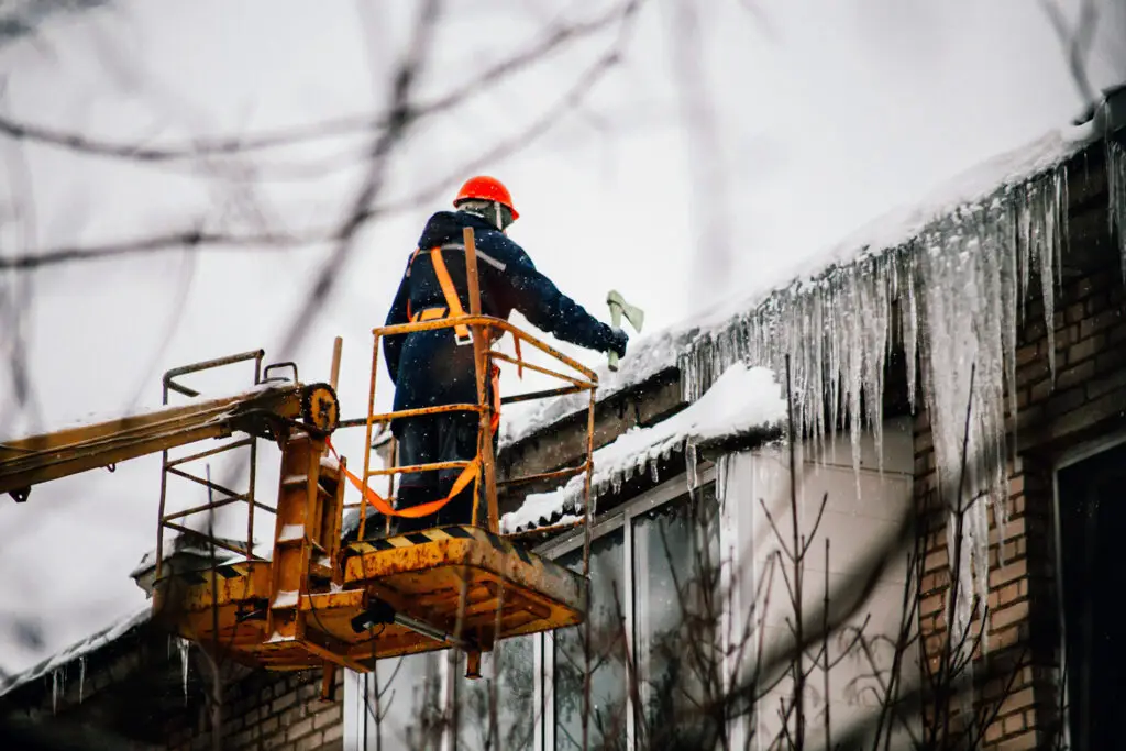 a utility worker knocks down huge icicles 2023 11 27 05 24 38 utc